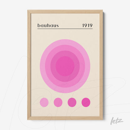 poster print of geometric bauhaus style art in shades of pink with a narrow light wood frame