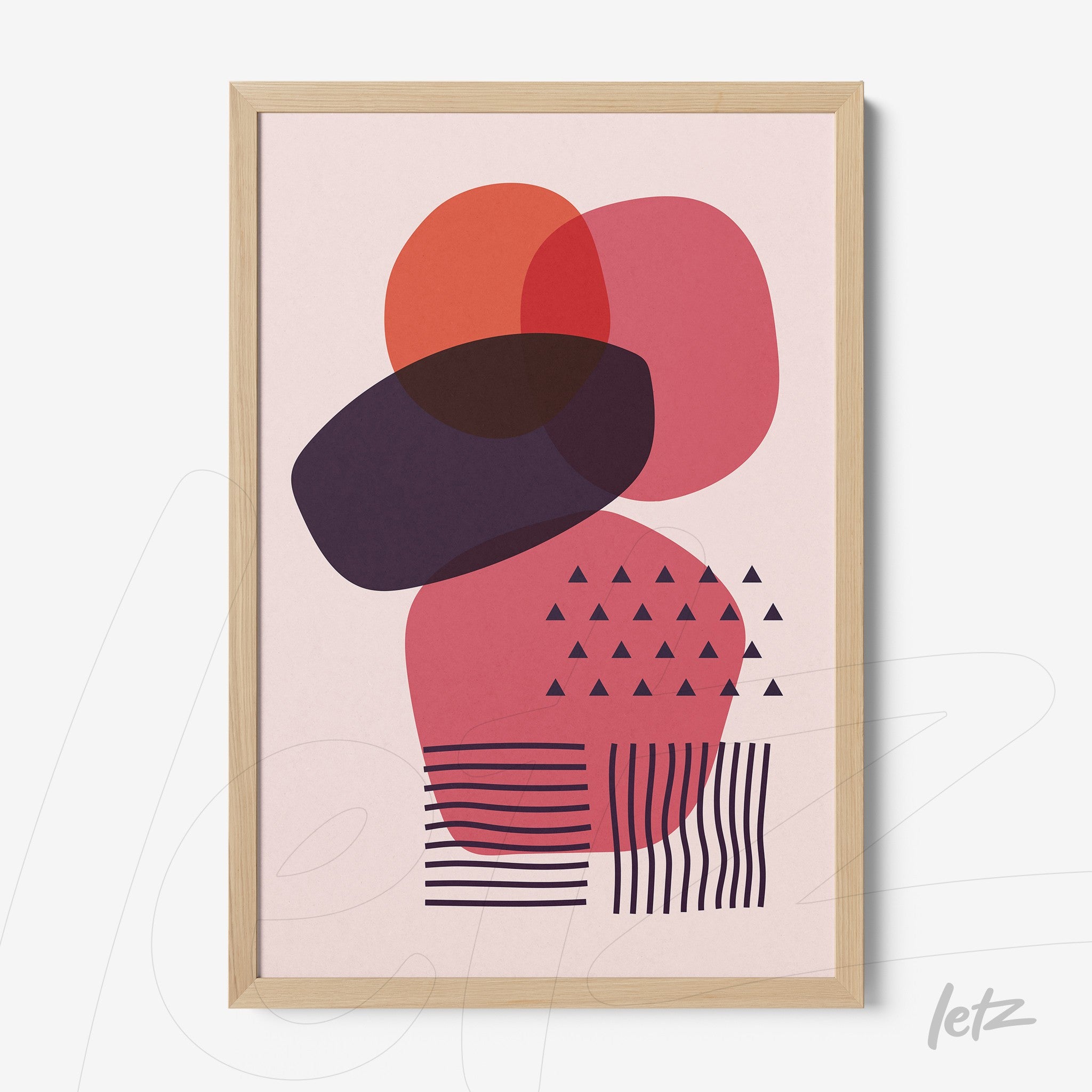 poster featuring colorful geometric shapes in shades of red and purple with light wood frame