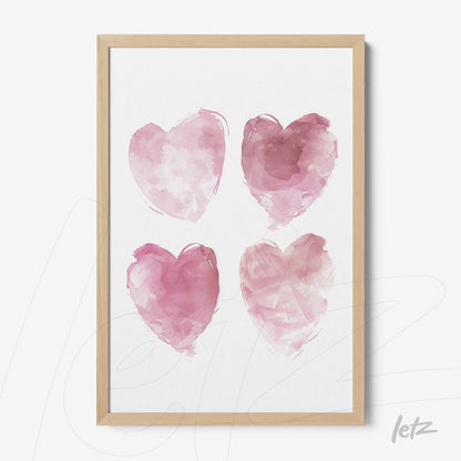 framed wall art featuring four pink watercolor hearts in light wood frame