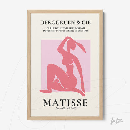 framed modern art print in pink featuring a seated female figure with light wooden frame