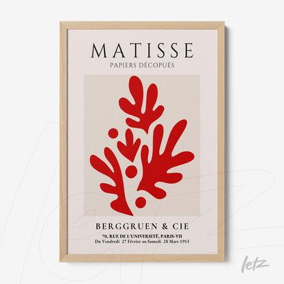 framed wall art featuring red paper cutout design with light wooden frame and neutral background