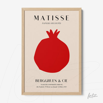 framed modern art featuring a red pomegranate on a light background with a light wood frame