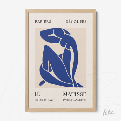 decorative wall art featuring modernist blue cut-out of a seated female figure with a light wood frame
