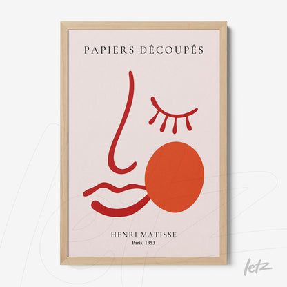 framed wall art featuring an abstract stylized face design in light background, with red lines and a round orange shape