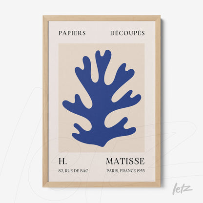 modern framed artwork featuring paper cutout of a blue coral on a neutral background with light wooden frame