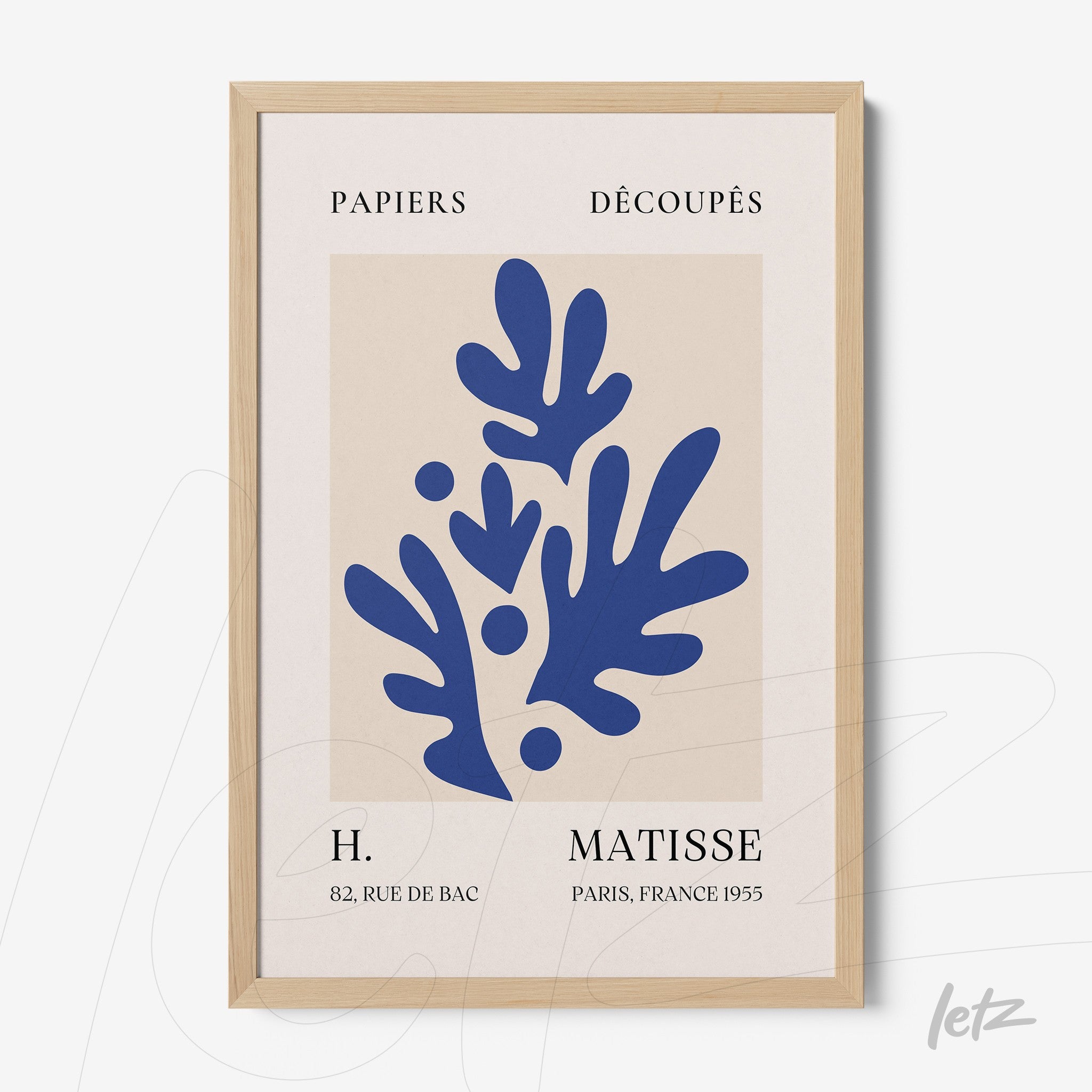 framed wall art featuring abstract blue leaves on light background with light wood frame