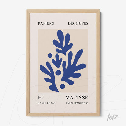 framed wall art featuring abstract blue leaves on light background with light wood frame