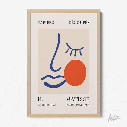 contemporary framed art featuring an abstract face in vibrant colors with light wood frame