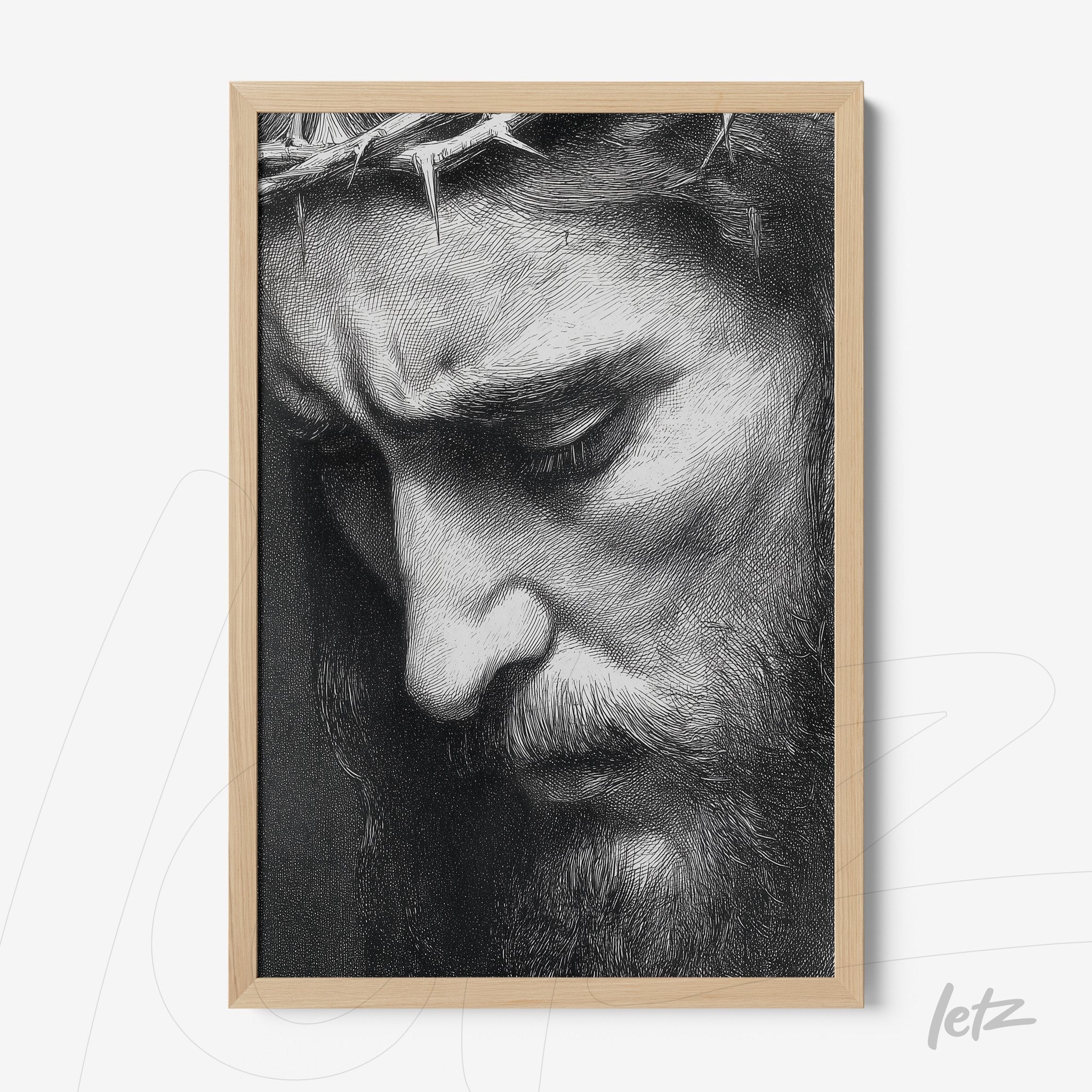 framed artwork in black and white depicting the sorrowful face of Jesus with a crown of thorns and light wood frame
