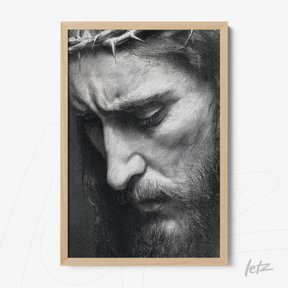framed artwork in black and white depicting the sorrowful face of Jesus with a crown of thorns and light wood frame