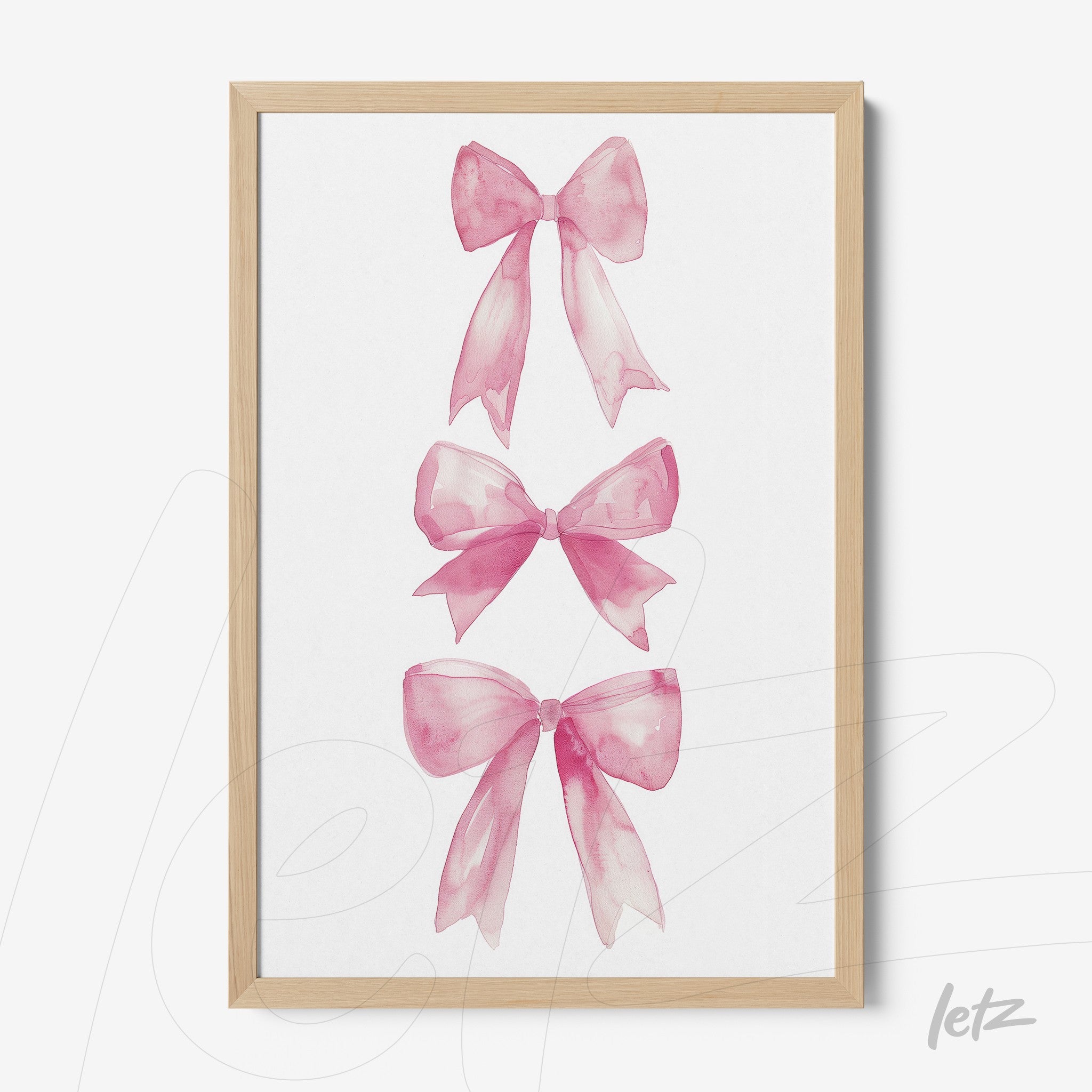 framed art featuring three pink watercolor bows displayed in a light wood frame