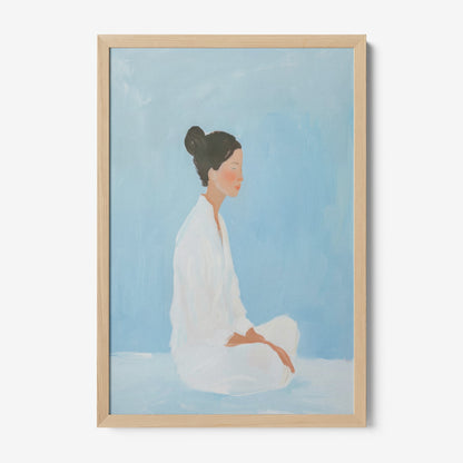 framed minimalist art of a woman meditating against a light blue background with a light wood frame