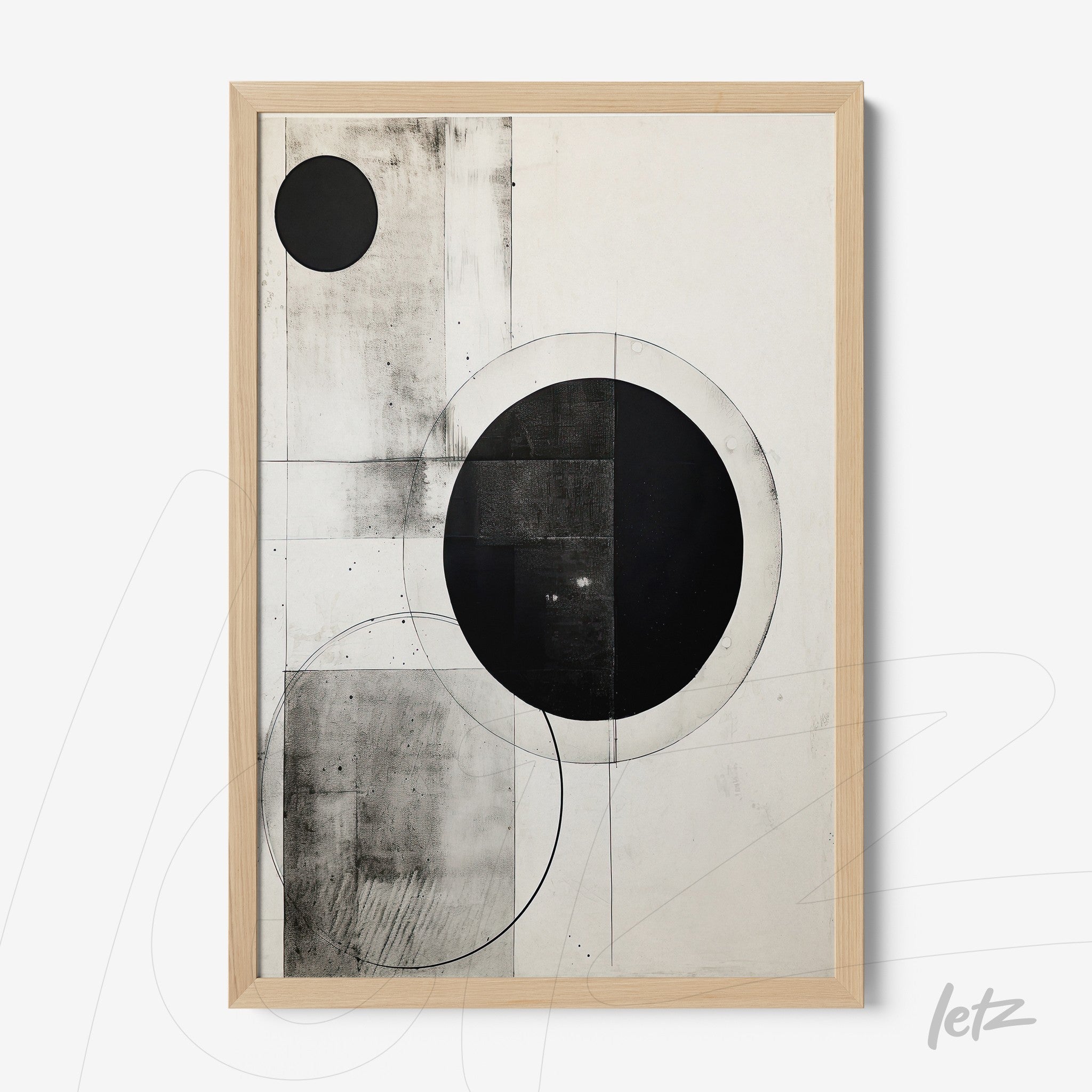 framed abstract art in black and white featuring circles and geometric shapes on light background with light wooden frame