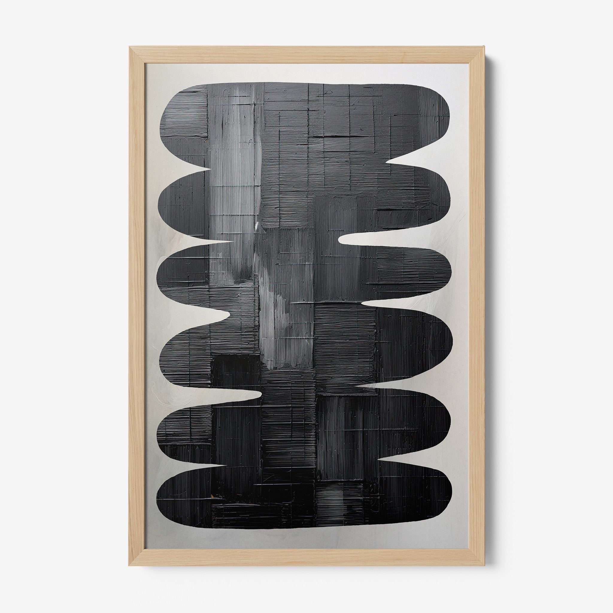 framed abstract art in shades of black and gray with light wood frame