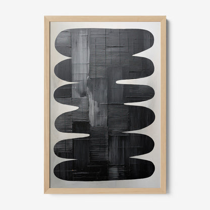 framed abstract art in shades of black and gray with light wood frame