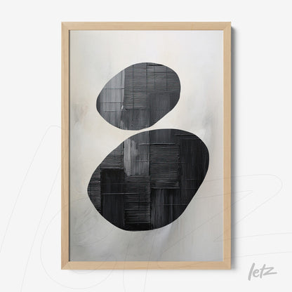 abstract art piece in black and white framed with light wood