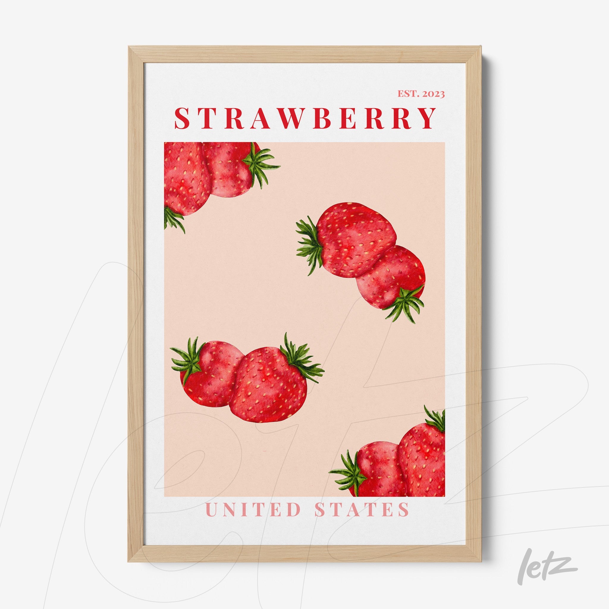 framed wall art featuring strawberries on a pink background with a light wood frame