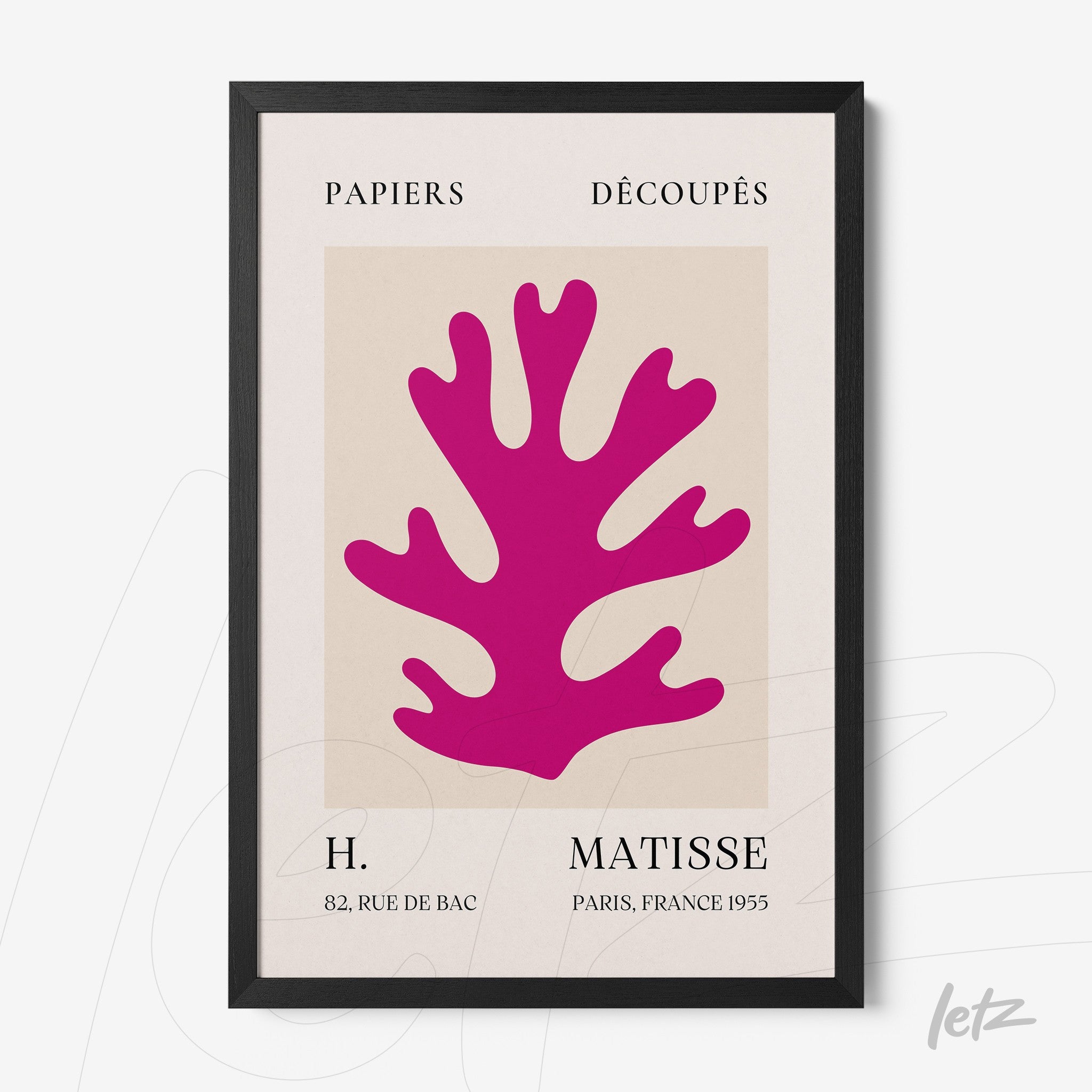 framed wall art featuring pink cut-out paper design with a black frame and light background