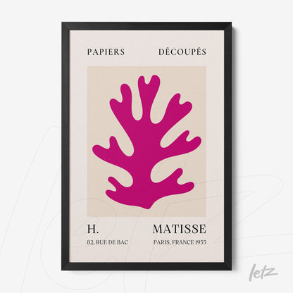 framed wall art featuring pink cut-out paper design with a black frame and light background