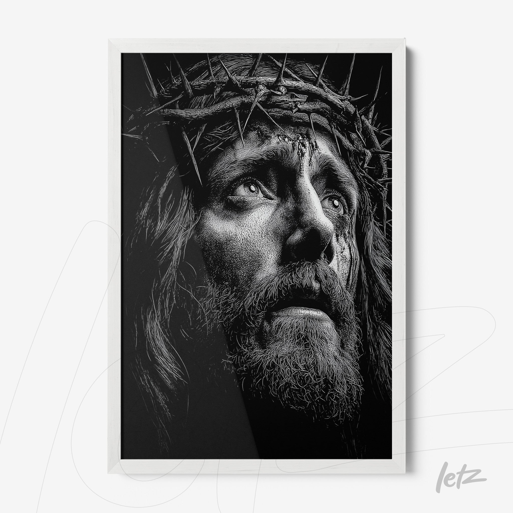 framed black and white artwork of Christ's face with a crown of thorns in white frame