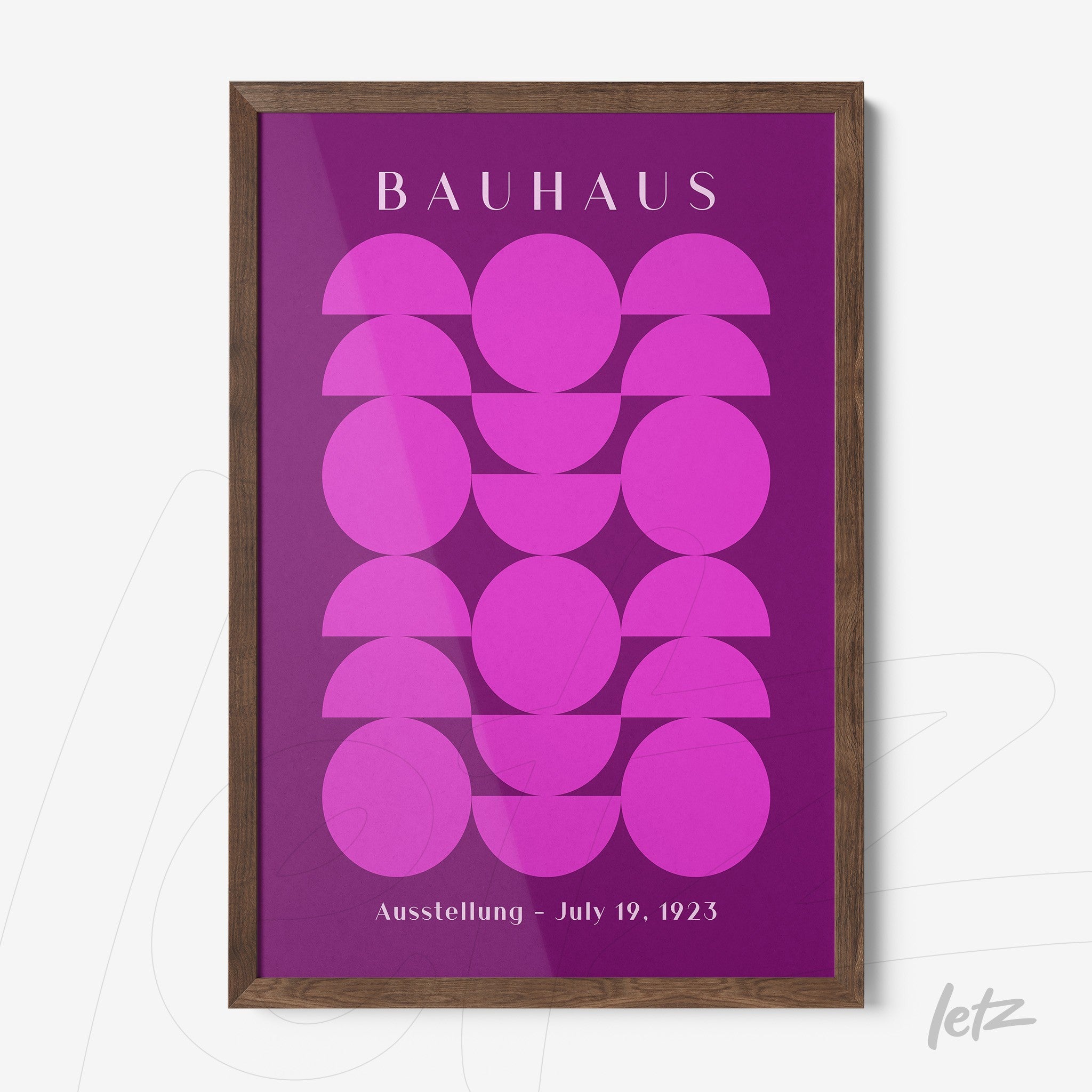 poster with geometric pattern in shades of pink framed in dark wood