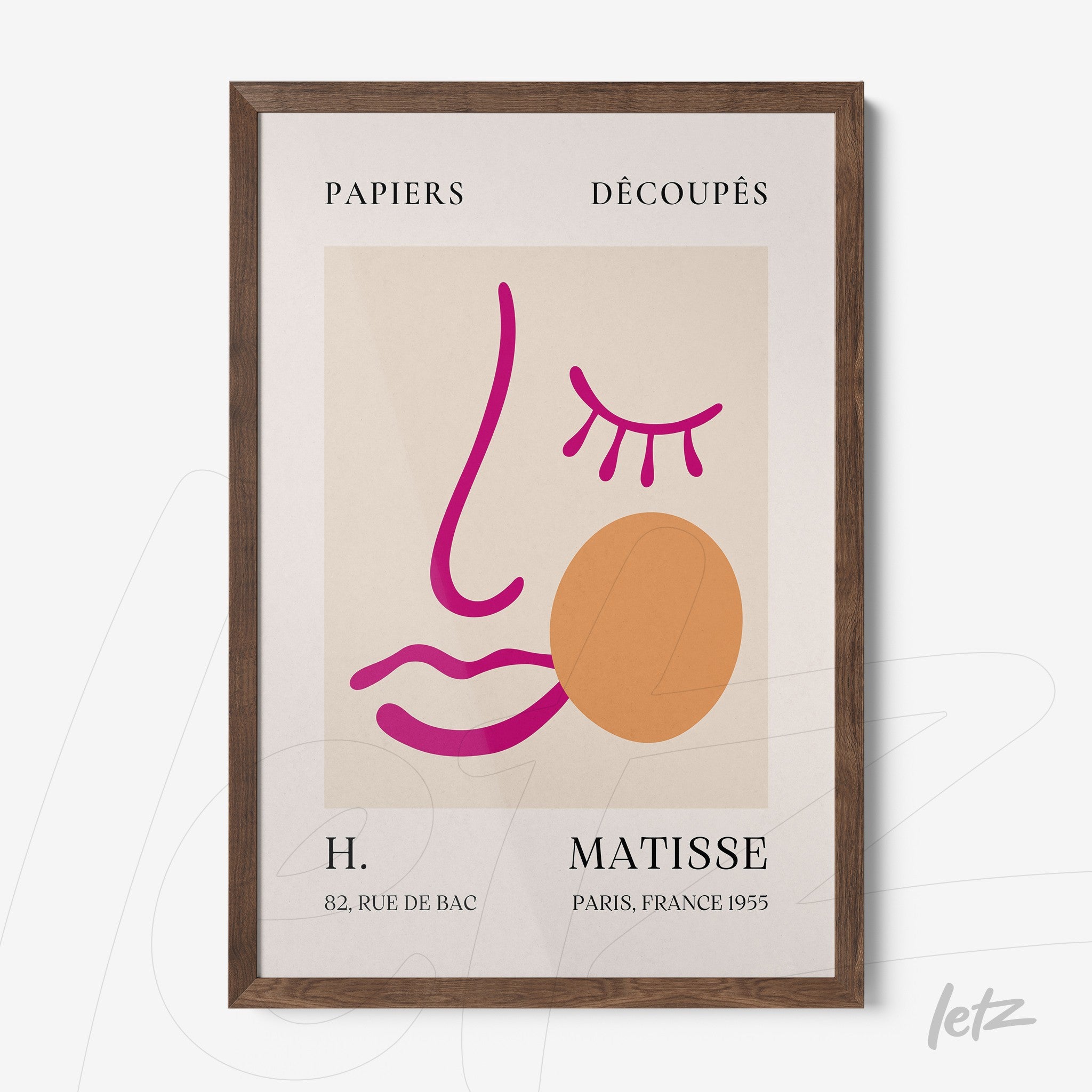 framed modern wall art featuring a stylized face in pink and orange tones with a dark wood frame against a cream background