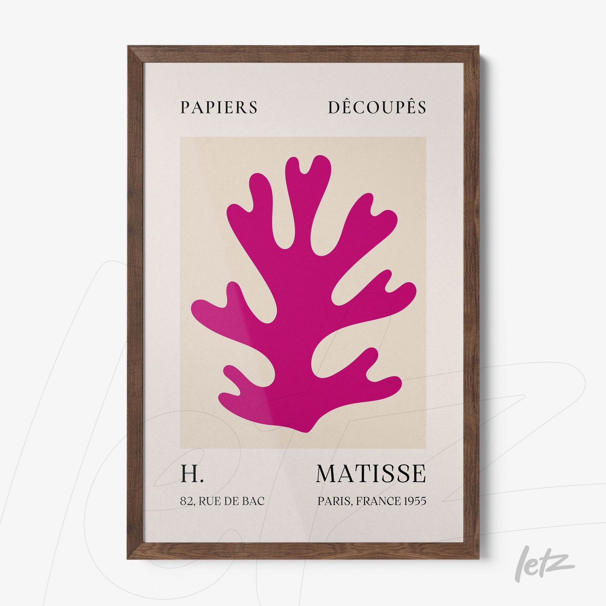 framed modern art featuring a pink cut-out coral shape on a light background with a dark wood frame