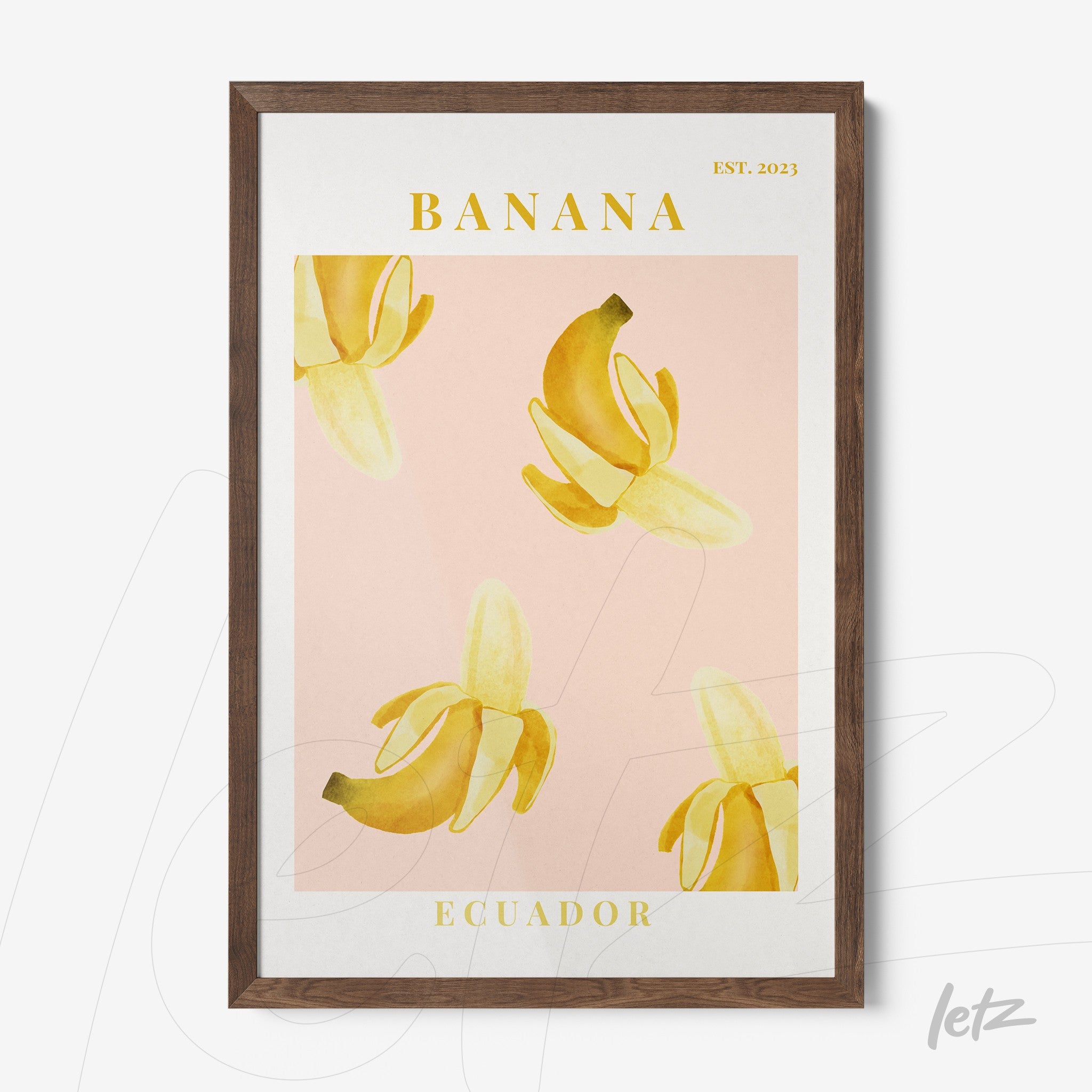 framed wall art featuring banana illustrations on a pink background with dark wood frame
