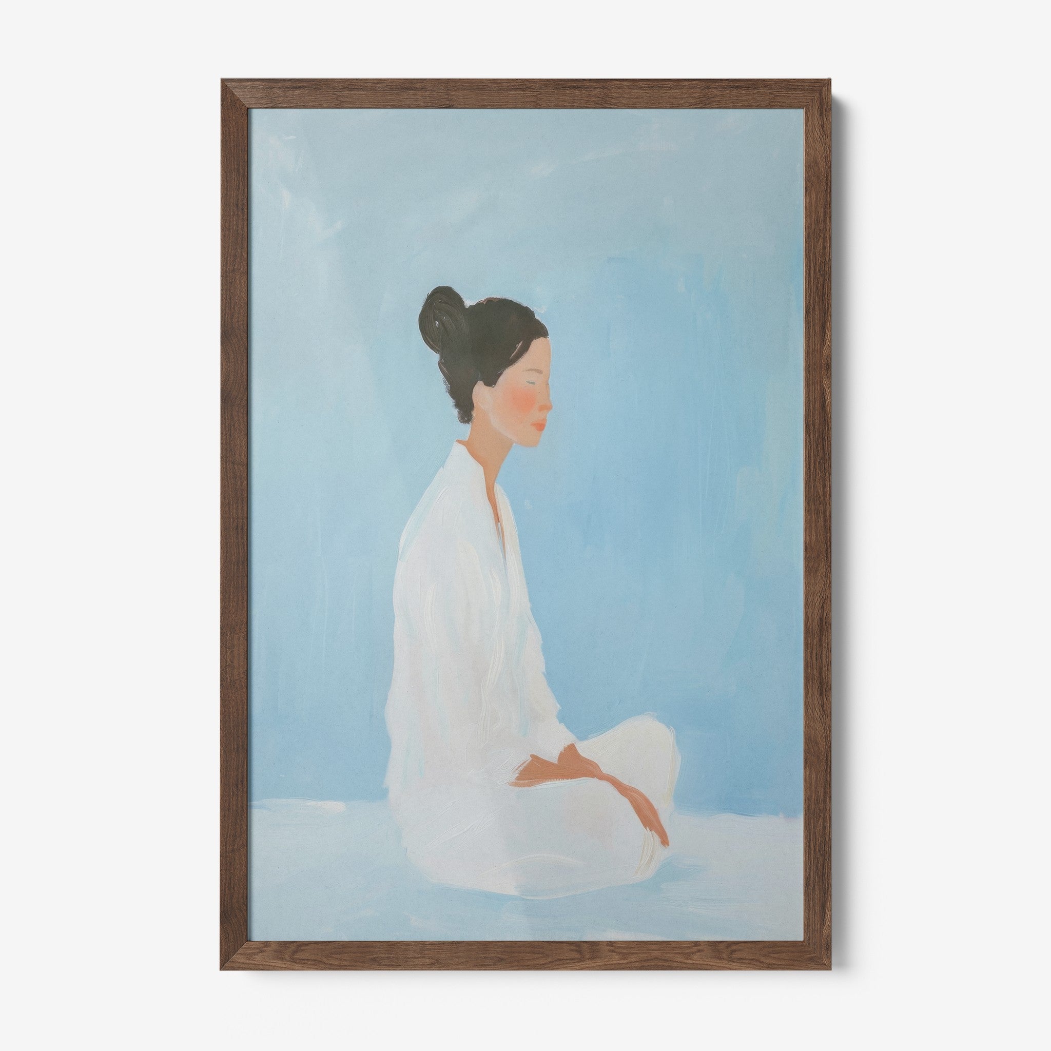 framed artwork of a woman in a meditative pose with dark wood frame and soft blue background