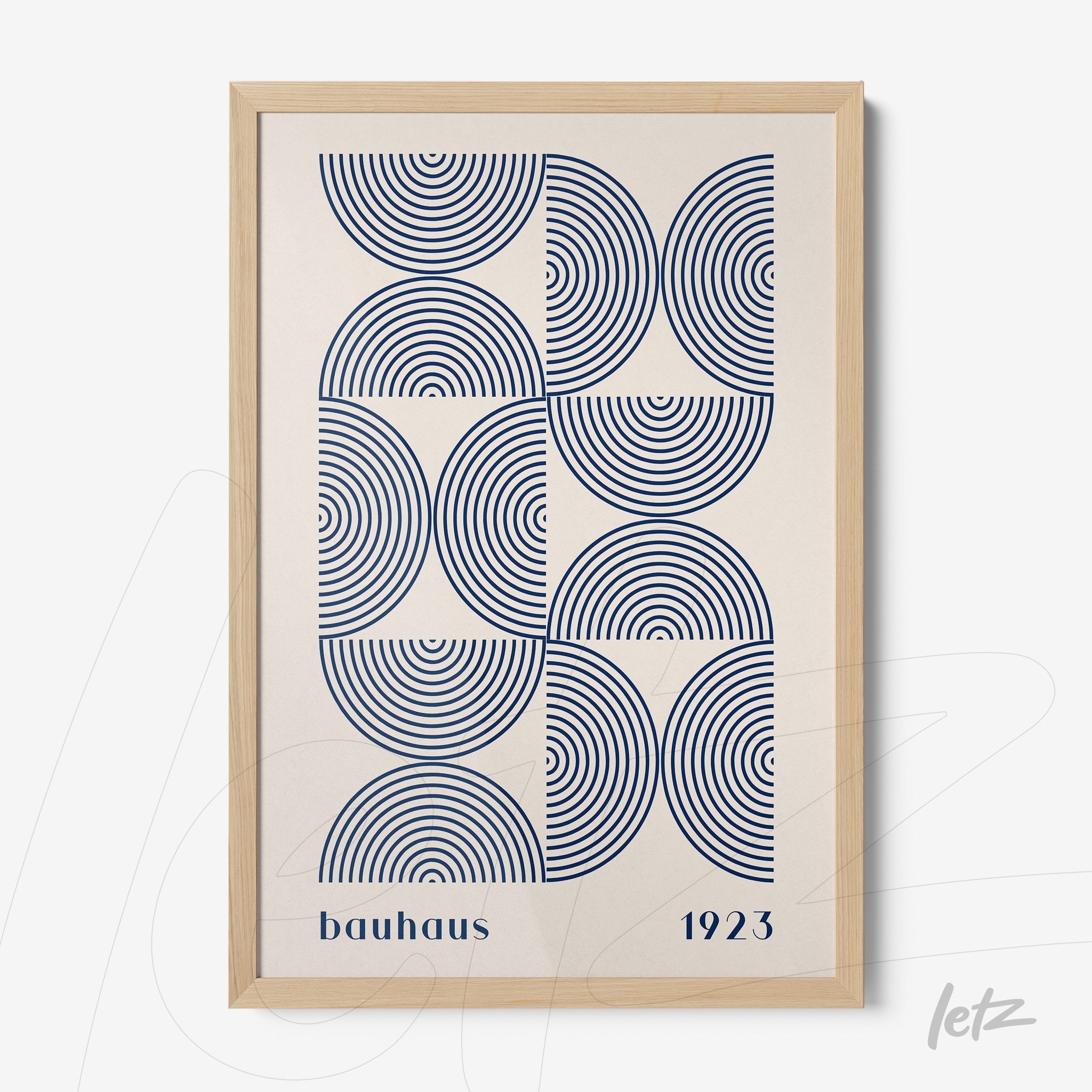 poster featuring a geometric design with blue concentric circles and 'bauhaus 1923' text, framed in light wood