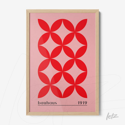 poster with red geometric pattern on pink background in a light wood frame
