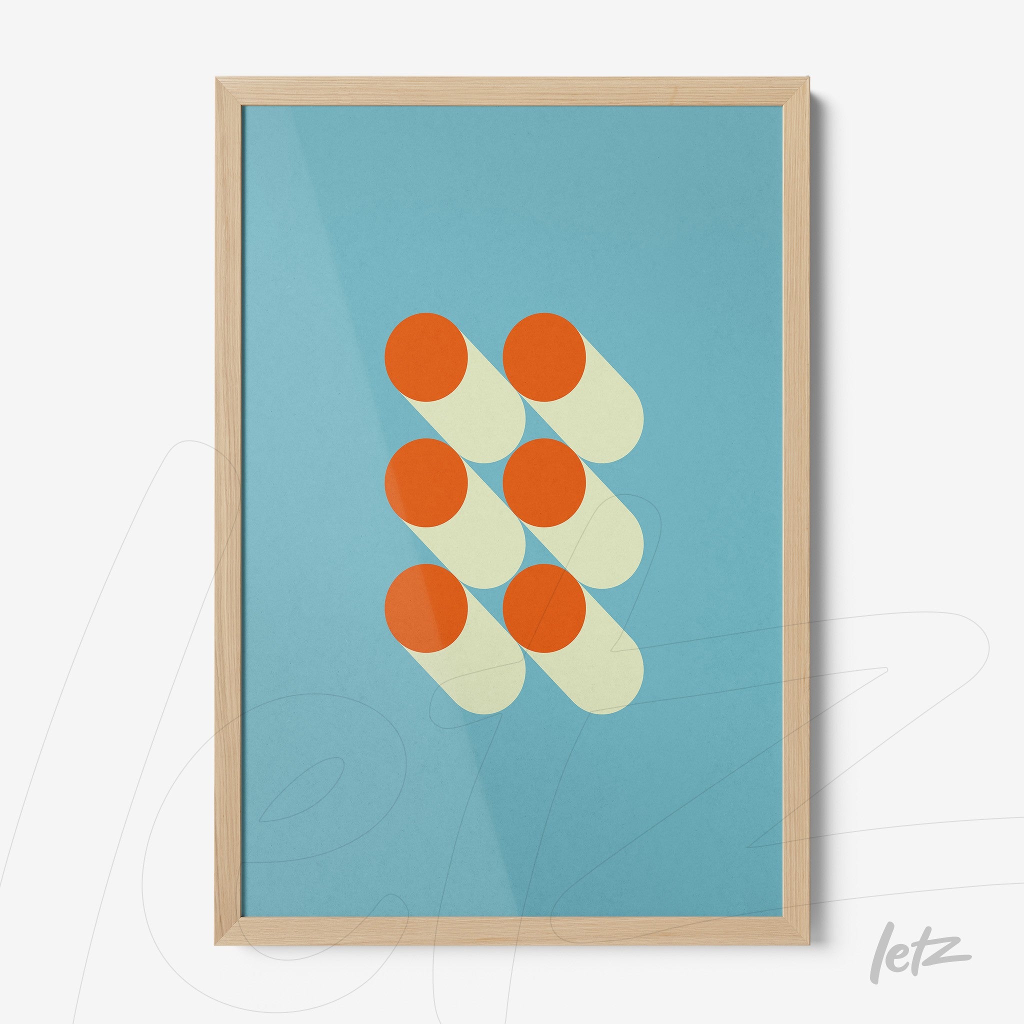 geometric print with orange circles on blue background in light wood frame