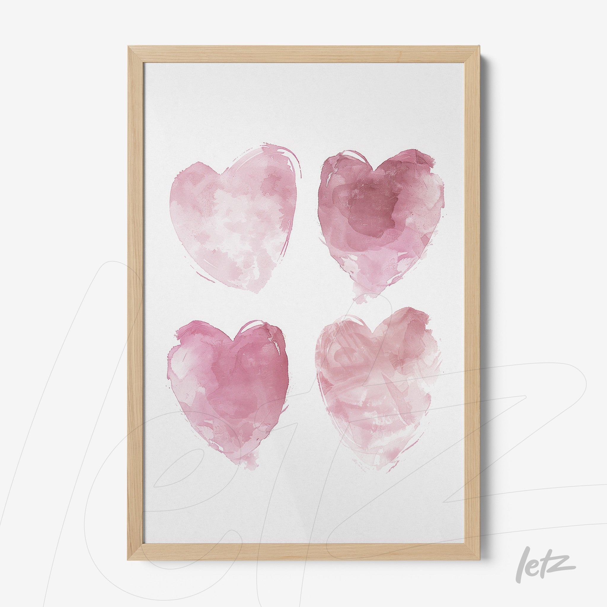 framed wall art displaying four watercolor hearts in shades of pink with a light wooden frame