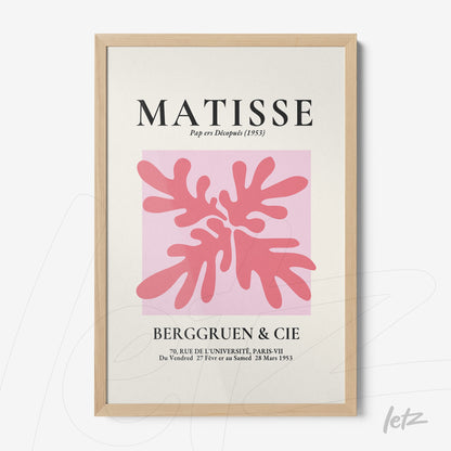 framed modern artwork featuring light pink foliage on a pink background with decorative text and light wood frame