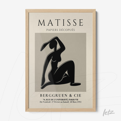 framed modern wall art featuring a black silhouette of a female figure against a gray background with light wood frame