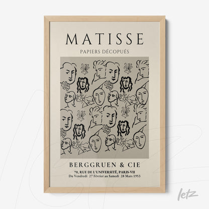 framed wall art featuring modern style faces and shapes on a light background with light wood frame