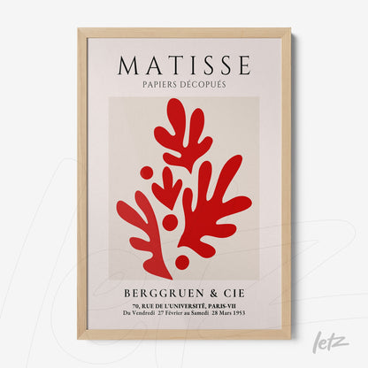 framed artwork featuring red cut-out shapes inspired by Matisse with light wood frame