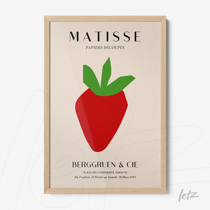 framed wall art featuring a stylized strawberry in vibrant colors with a light wood frame and neutral background