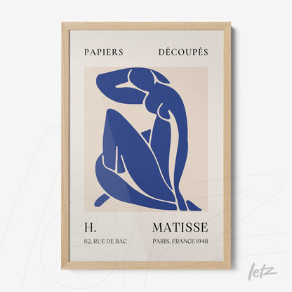 framed wall art featuring modern paper cut style in blue tones with light wood frame