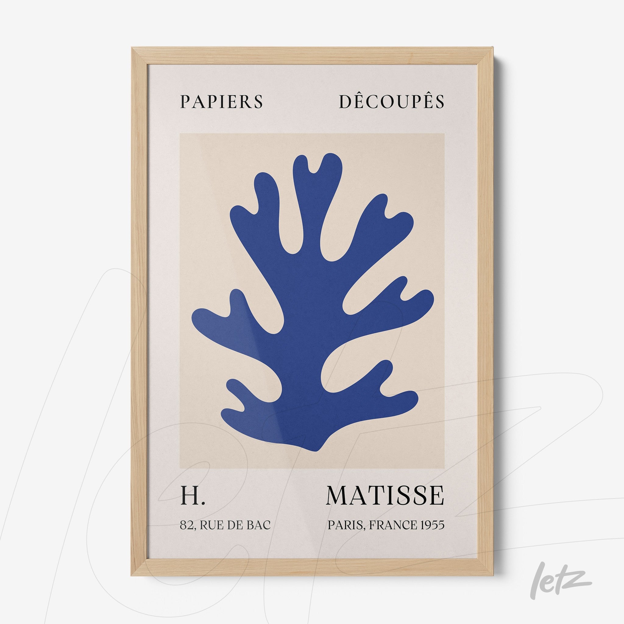 framed wall art featuring a blue coral silhouette on a neutral background with a light wood frame