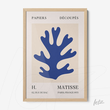 framed wall art featuring a blue coral silhouette on a neutral background with a light wood frame