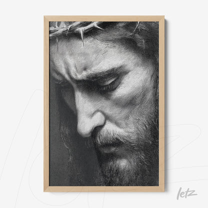 framed artwork in light wood depicting a black and white close-up of Christ's face expressing pain