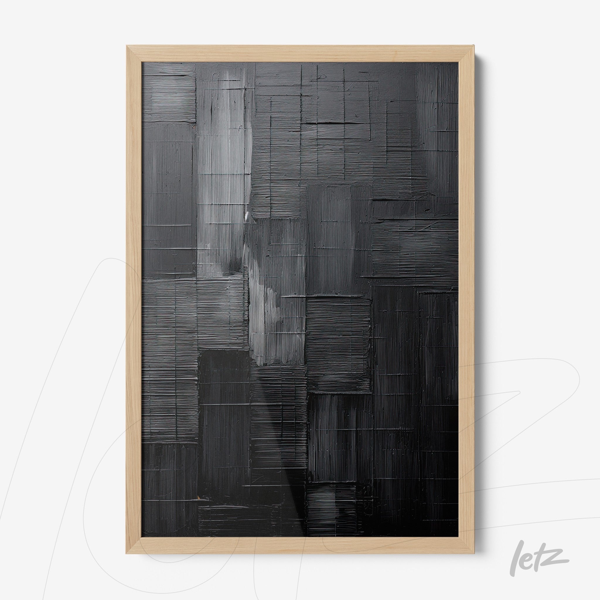 abstract wall art in shades of black and gray presented in a light wood frame