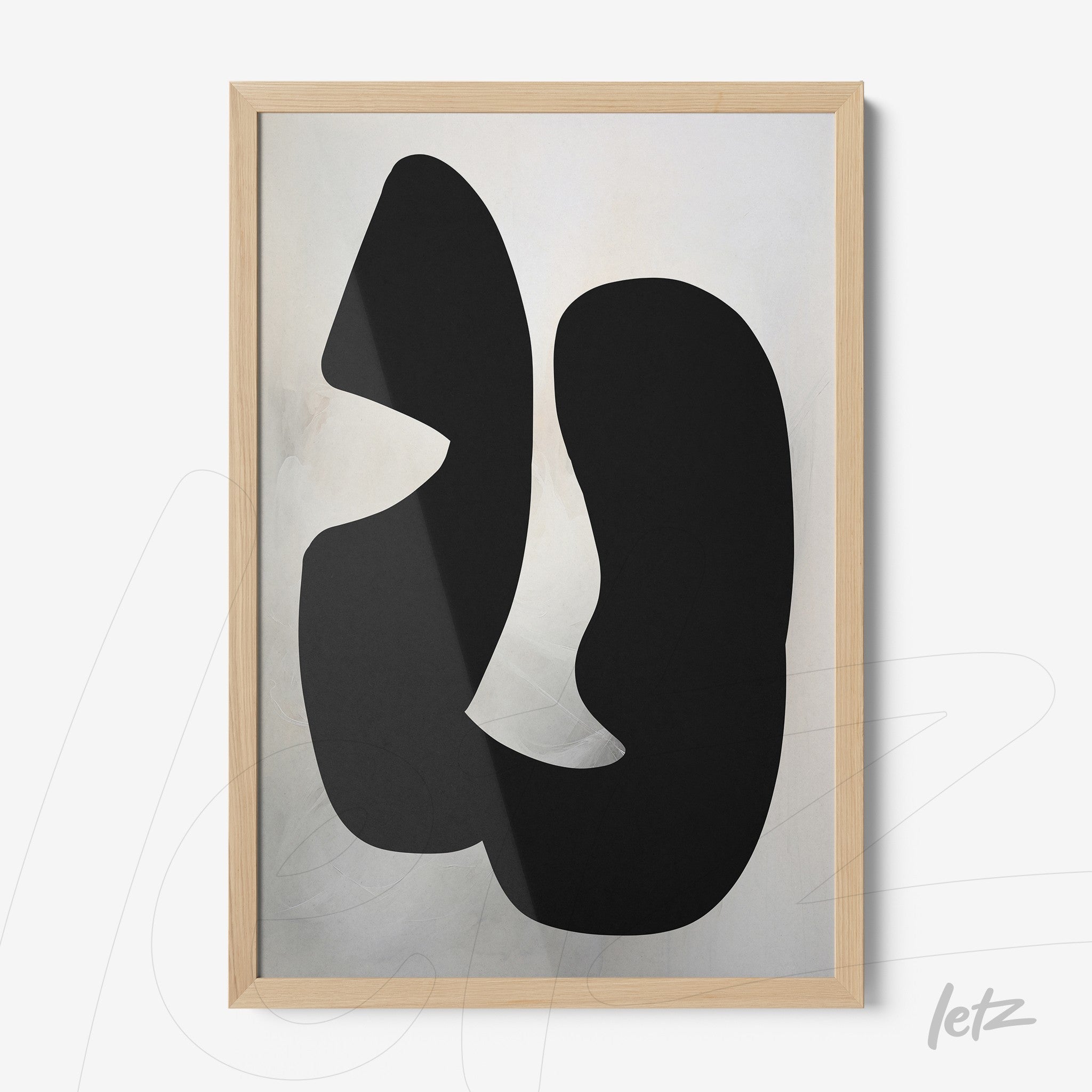 abstract wall art with black shapes on light background in light wood frame