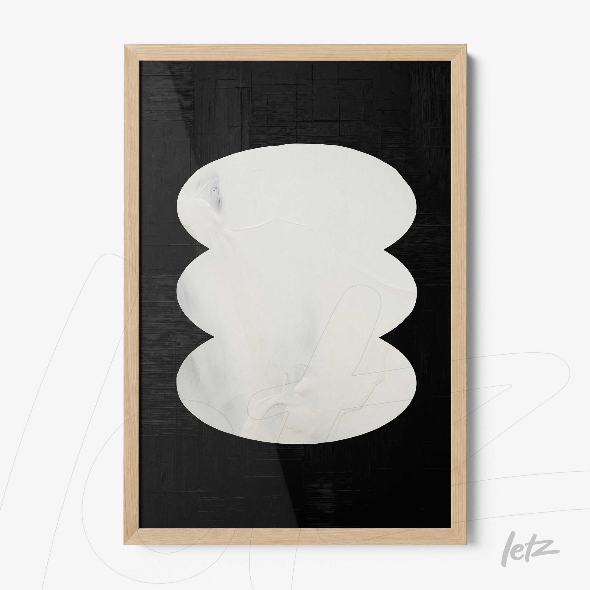 abstract art with white organic shapes on a black background, framed in light wood