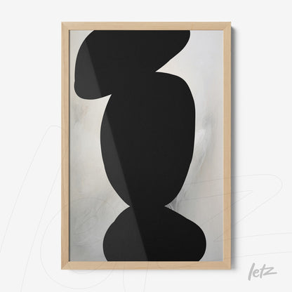 framed abstract art featuring neutral tones and black shapes in light wood frame