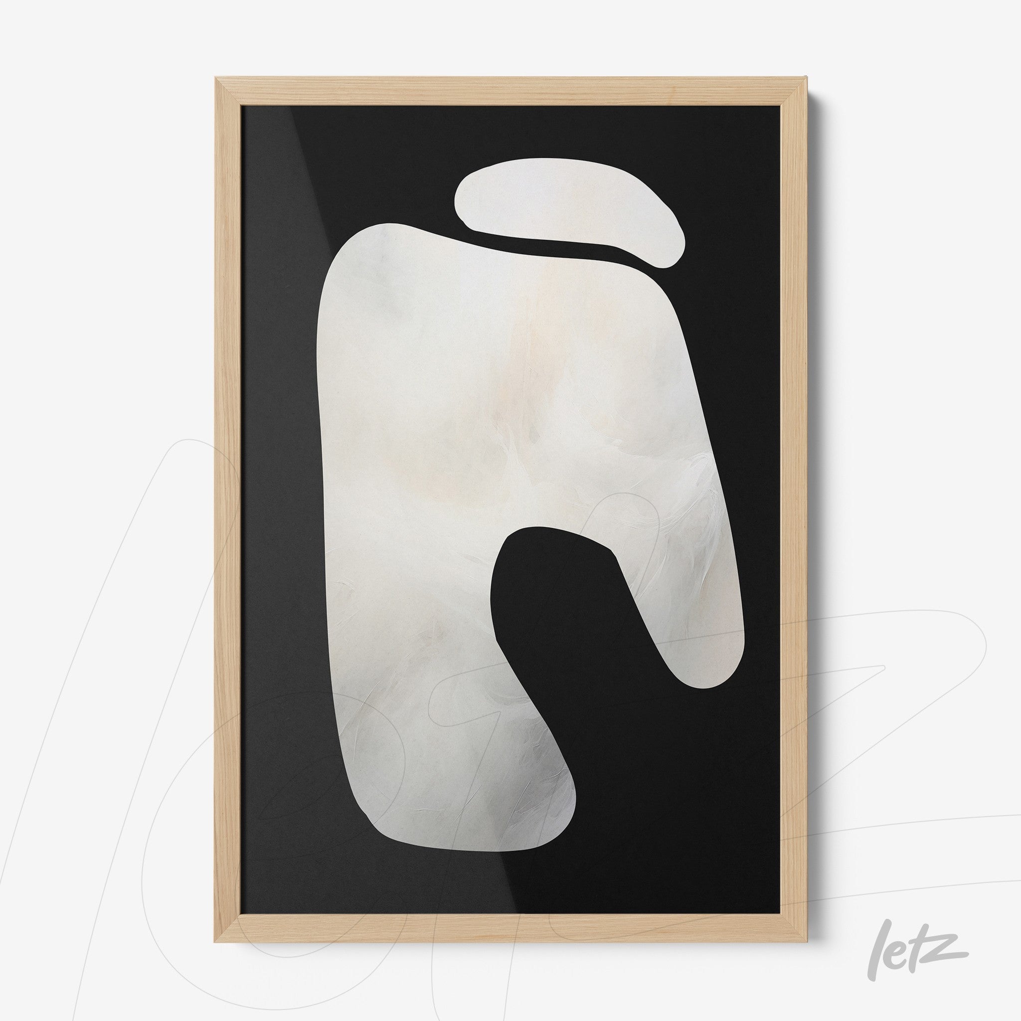 framed wall art featuring abstract design on black background with light wood frame