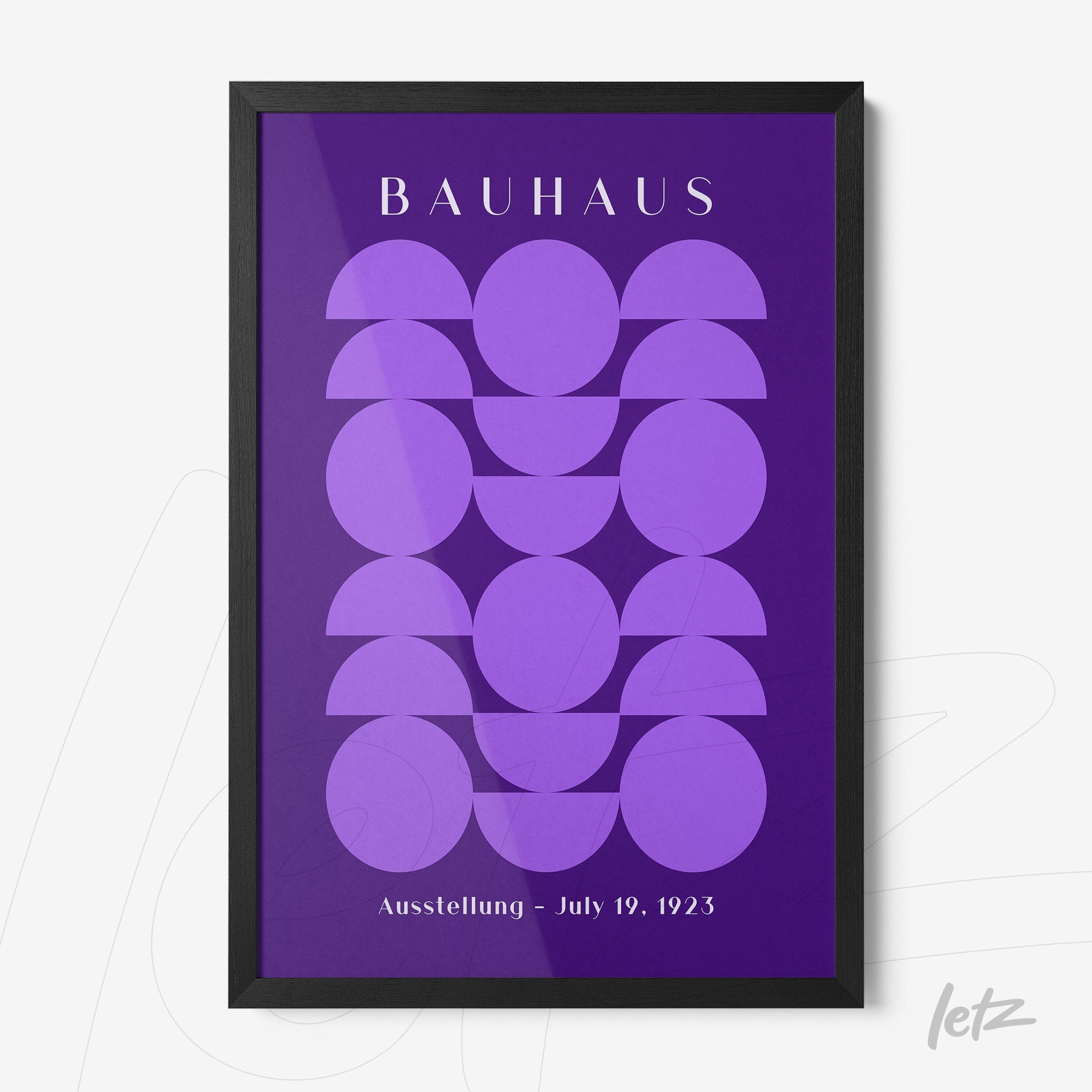 framed wall art featuring geometric shapes in purple hues, with the text 'bauhaus' at the top and 'ausstellung - july 19, 1923' at the bottom, in a black frame
