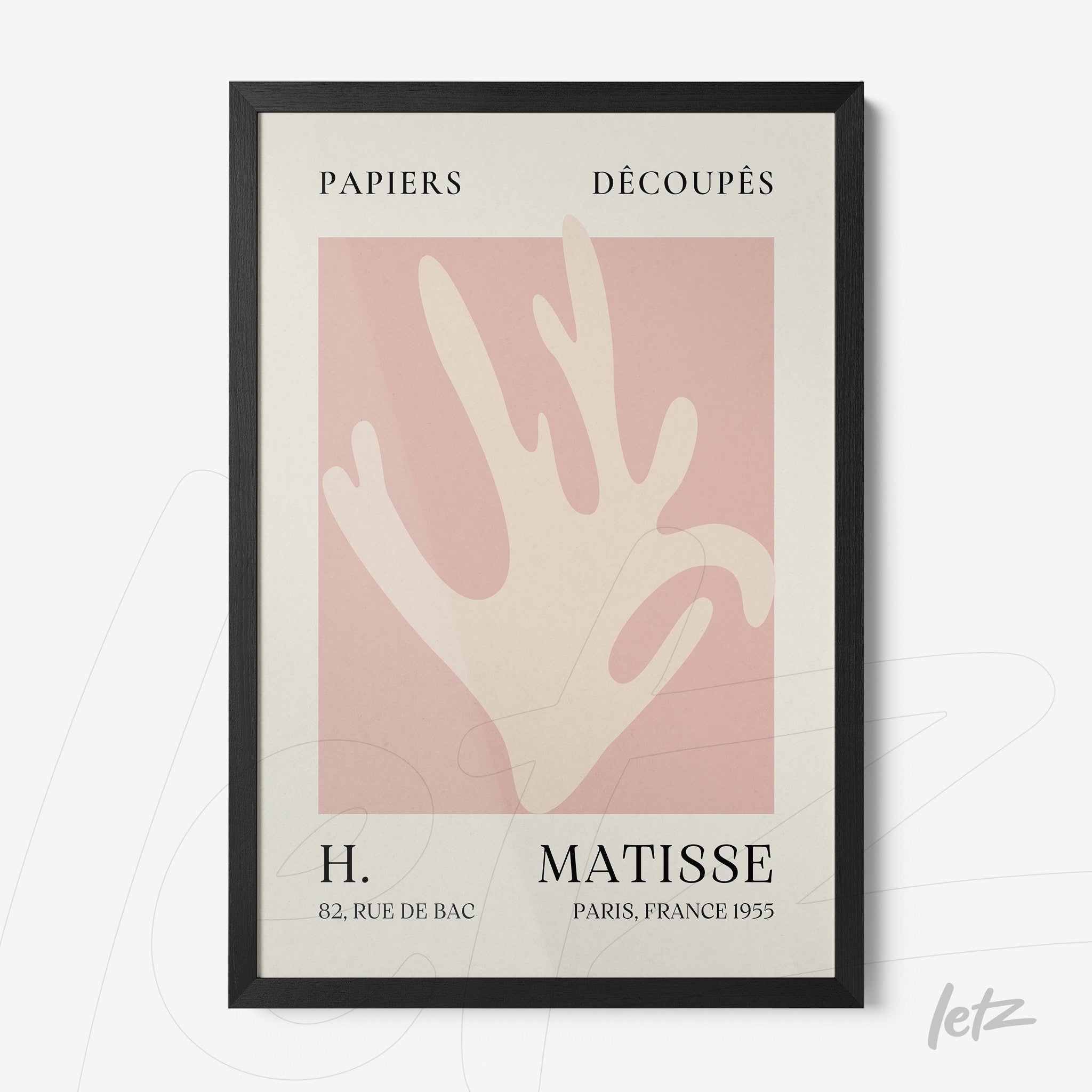 framed artwork featuring an abstract hand design on a light pink background with elegant black frame and french text