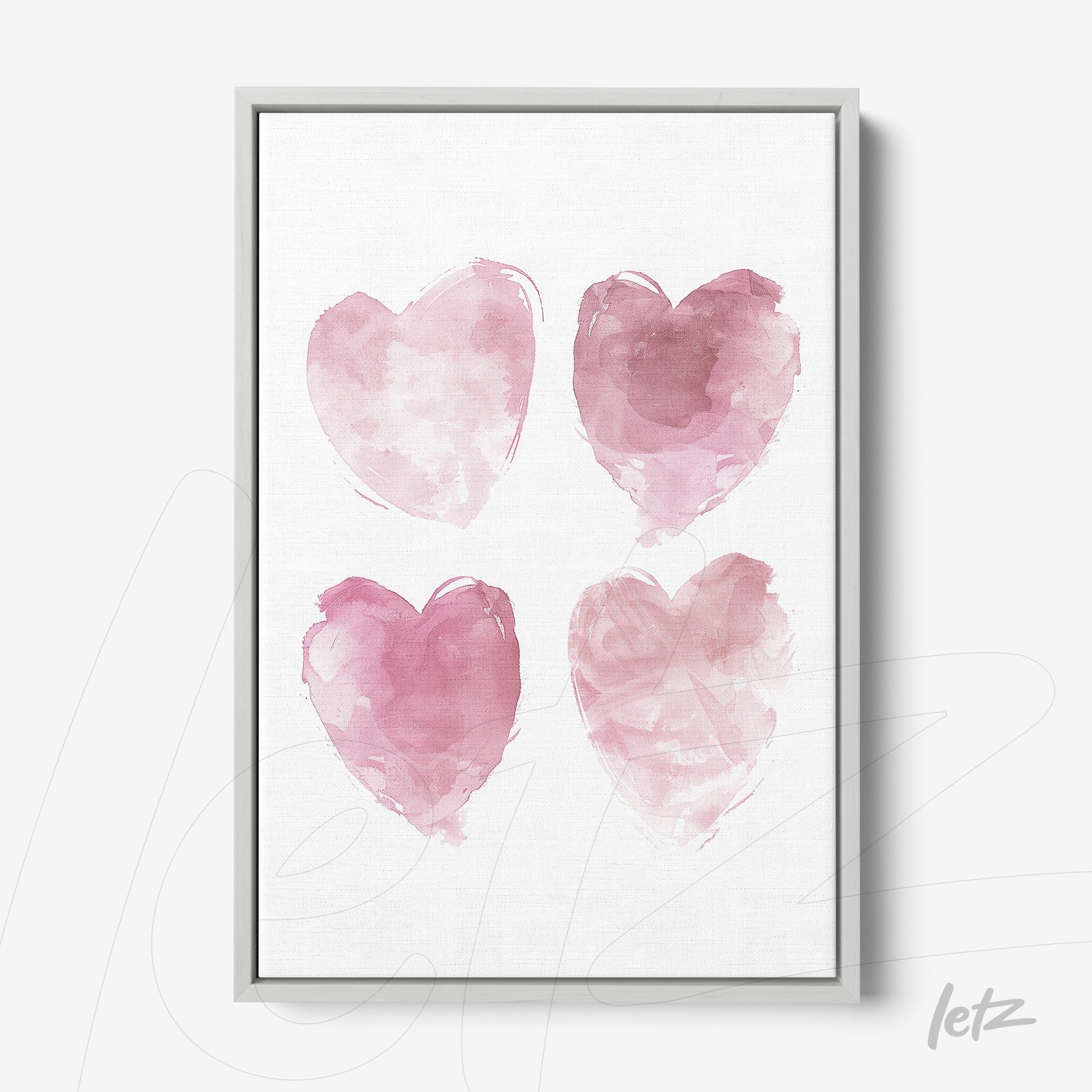 decorative wall art featuring four watercolor hearts in shades of pink with silver frame